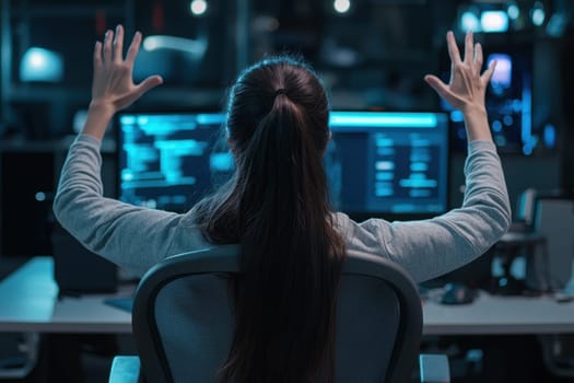 A woman is sitting at a desk with her hands raised in the air. She is looking at a computer screen with a frown on her face. Scene is tense and frustrated