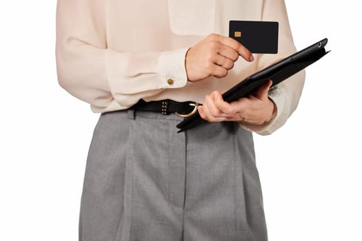 woman in white blouse and grey pants using credit card and digital tablet on white background