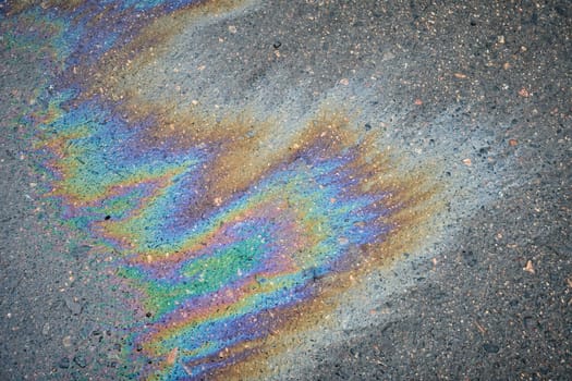Moist pavement in a parking lot, highlighting a motor oil leak from a vehicle