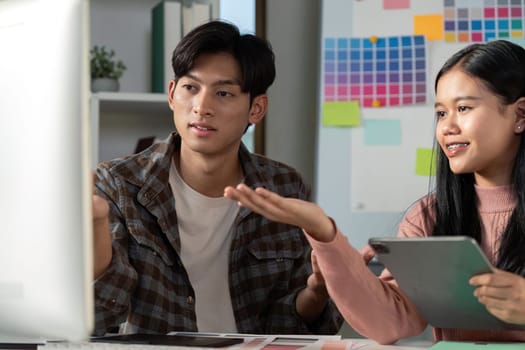 A diverse team engaging in a discussion about graphic design ideas while working in a creative office environment.