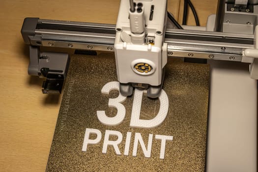 Modern 3d printer creating the words in white petg