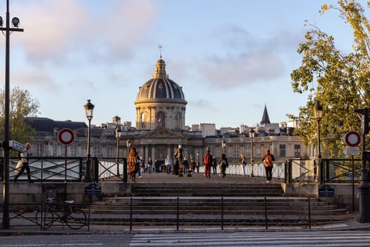 Paris with beautiful buildings, cars and people passing by on the street. Paris, France - February 10, 2025