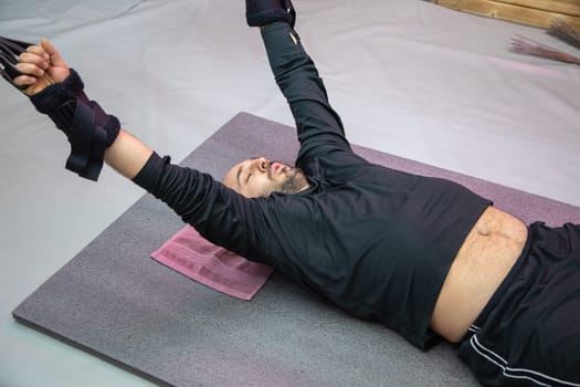 Athlete performing a suspension training exercise, strengthening his upper body and core muscles