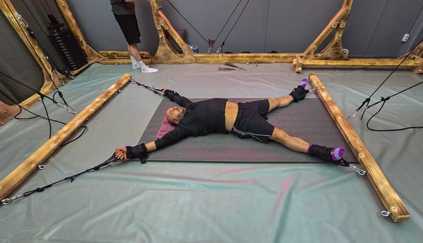 Patient doing antigravity yoga exercises with elastic bands in rehabilitation center
