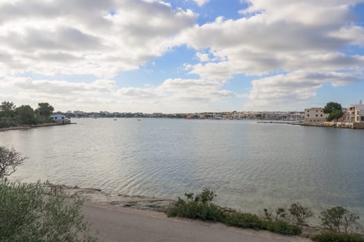 Portocolom, small bay, with the village and fishermen's houses in the background on a cloudy day Mallorca ,Balearic Islands, Spain
