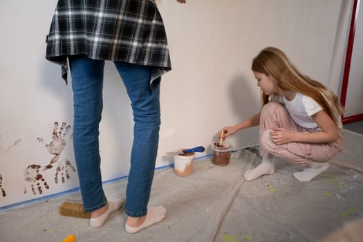 A lively and joyful scene depicting children engaging in painting a colorful wall during a home renovation project