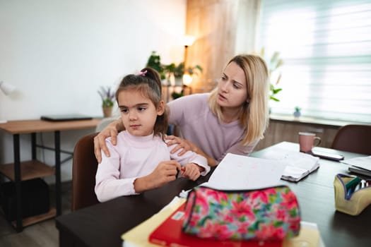 A mother provides emotional support to her daughter while studying.