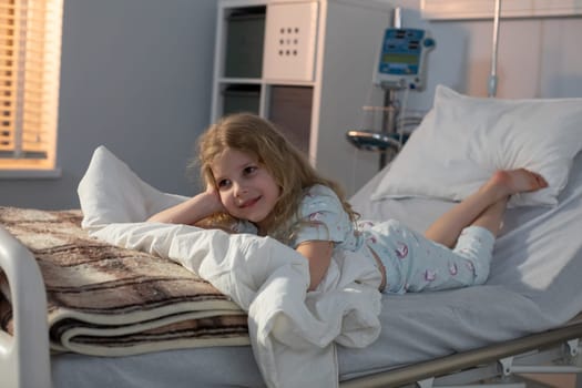 A young girl is relaxing in her hospital bed, displaying remarkable resilience and heartfelt optimism during her stay