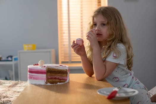 In a softly lit, cozy environment, a young girl is truly savoring a delightful piece of cake filled with joy