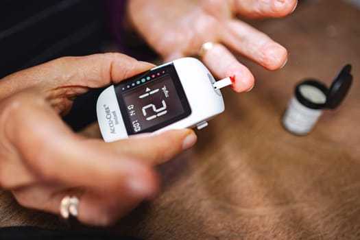 Checking blood sugar levels with a glucose meter while at home.