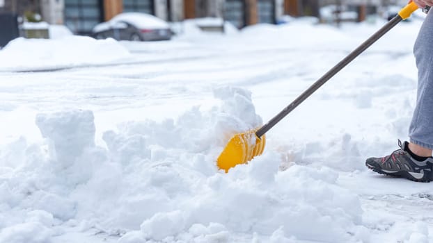 Man shoveling snow off of his driveway after a winter storm in Canada. Man with snow shovel cleans sidewalks in winter. Winter time