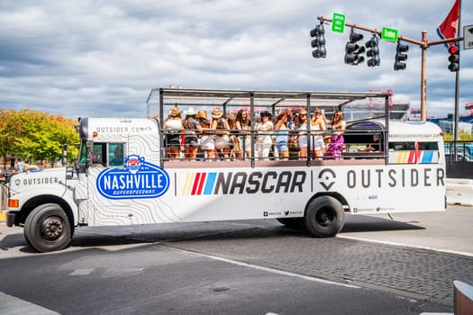 October 13, 2023, Nashville, TN: NASCAR-themed open platform bus full of women celebrating and having fun in downtown Nashville