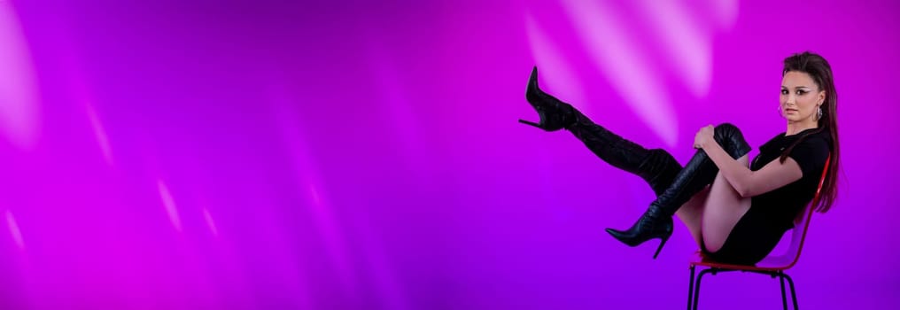 The chic model confidently showcases bold and vibrant fashion against a striking purple ambiance that captivates