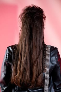 A stylish individual with long, flowing hair, seen from the back, captured in a vibrant, energetic environment