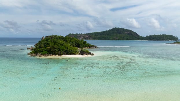 Small island with vibrant foliage, white sand beaches, and clear waters. Seychelles, Mahe.