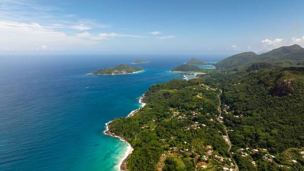Coastline with sandy beaches, turquoise waters, and dense tropical greenery. Seychelles, Mahe.