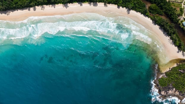 A beach with azure waves and tropical vegetation. Seychelles, Mahe. Grand Anse Beach.
