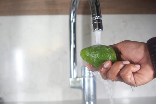hand washing avocado with water sprinkling.