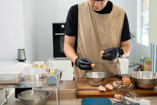 Baker separating eggs preparing for a delicious batch of homemade cookies.