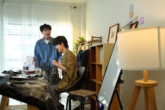 Two young designers work together in a stylish fashion studio.