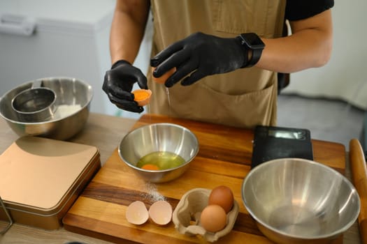 Baker separating eggs preparing for a delicious batch of homemade cookies.