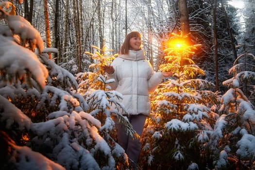 A middle-aged woman walks through a snowy forest, surrounded by snow-laden trees, celebrating the joy of winter and the festive season.