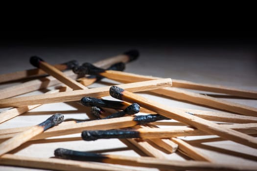 Low angle close-up view of burnt matches on a receding background.