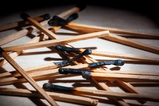 Low angle close-up view of burnt matches on a receding background.