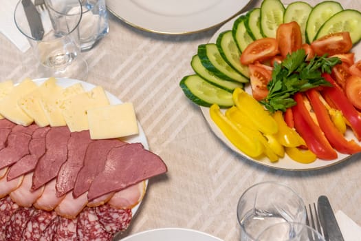 Shot of the table set up with assorted cut fresh vegetables, cold cuts, olives, salads.