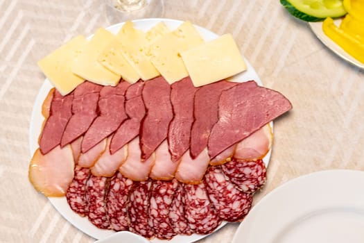 Shot of the table set up with assorted cut fresh vegetables, cold cuts, olives, salads.