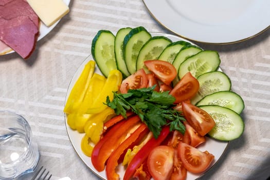Shot of the table set up with assorted cut fresh vegetables, cold cuts, olives, salads.