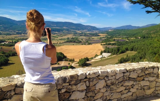 Girl takes pictures of the landscape of Provence, France