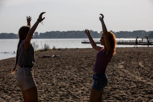 Two close friends are delighting in a blissful day at the beach while capturing the true essence of summer joy