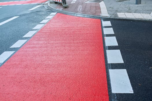 Freshly painted red bike path in the city.