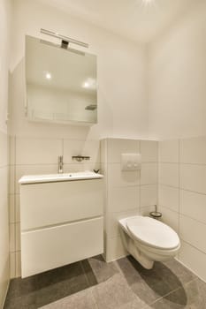 a bathroom with a toilet, sink and mirror on the wall next to it is a tiled floor that looks very clean