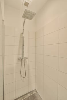 a bathroom with white tiles on the wall and shower head mounted to the wall in front of the bathtub