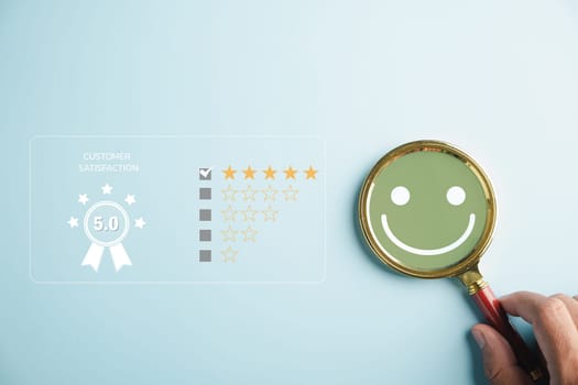 Magnifying glass held by hand selects happy smiley face icon among emotions. Good feedback rating, positive customer review. Experience, satisfaction survey, mental health concept. satisfaction.