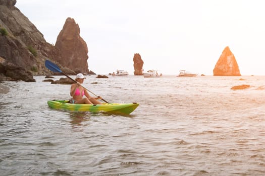 Kayaking. Travel adventure kayak on the tropical sea on a sunny day. Woman rowing a canoe.