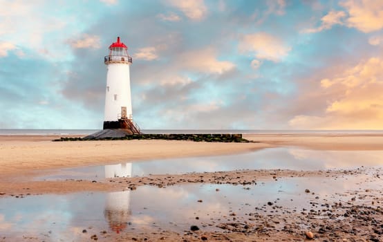 view of a lighthouse standing at the coast of Wales  the North Sea  at sinrise, United Kingdom