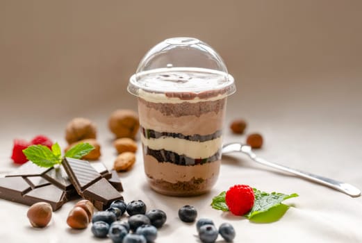 Chocolate Trifle in a cup with pieces of chocolate, strawberries, hazelnuts