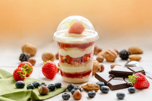 Chocolate Trifle in a cup with pieces of chocolate, strawberries, hazelnuts