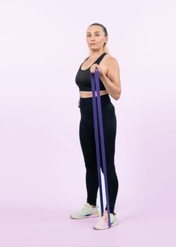 Full body length shot athletic and sporty senior woman with fitness resistance band on isolated background. Healthy active physique and body care lifestyle after retirement. Clout