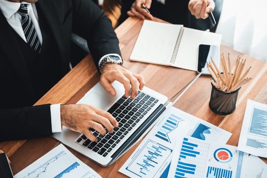 Diverse group of business analyst team analyzing financial data report paper on office table. Chart and graph dashboard by business intelligence analysis for strategic marketing planning Meticulous