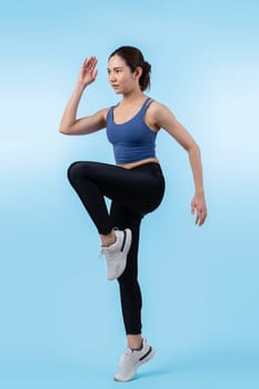 Side view young athletic asian woman on running posture in studio shot on isolated background. Pursuit of healthy fit body physique and cardio workout exercise lifestyle concept. Vigorous