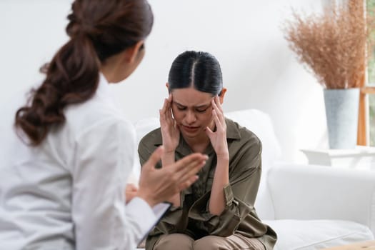 Sad PTSD woman patient in uttermost therapy for mental health with psychologist, depression or grief after life failure. Frustrated trauma young woman talking to a psychologist about emotion in clinic