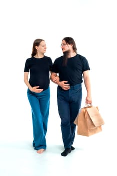 Portrait happy young pregnant woman and her husband with shopping bags and touching her big belly isolated on white background. Pregnancy shopping concept happy young family with shopping bags