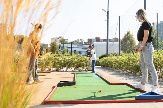 golfers with parents playing golf at sunny day. High quality photo