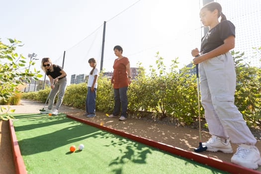 Kids playing golf inside playground artificial grass activity game for children . High quality photo