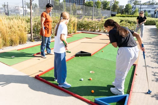 family playing mini golf on a cruise liner. Child having fun with active leisure on vacations. High quality photo