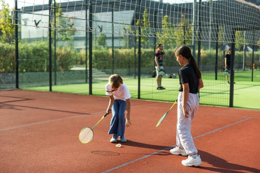 Two girls with badminton rackets on the football field. High quality photo